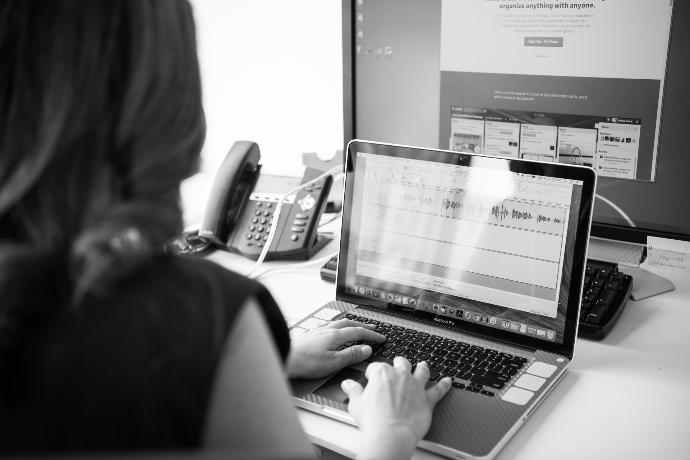 grayscale photo of person using laptop computer